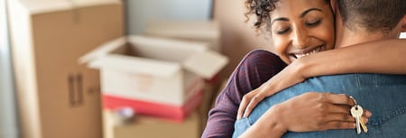 Couple embracing and celebrating home purchase  