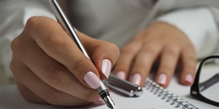 Women writing pro and con list for secured loan 