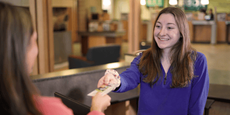 Teller helping Momentum Checking member make a deposit 