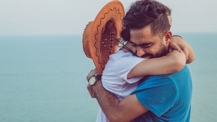 Excited couple embracing and celebrating consolidating their debt