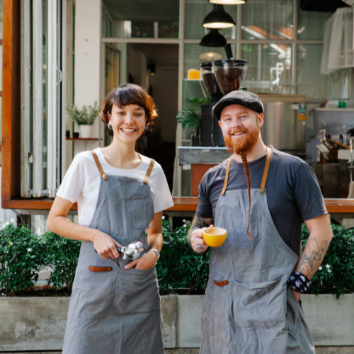 Two entrepreneurs stand outside a business.