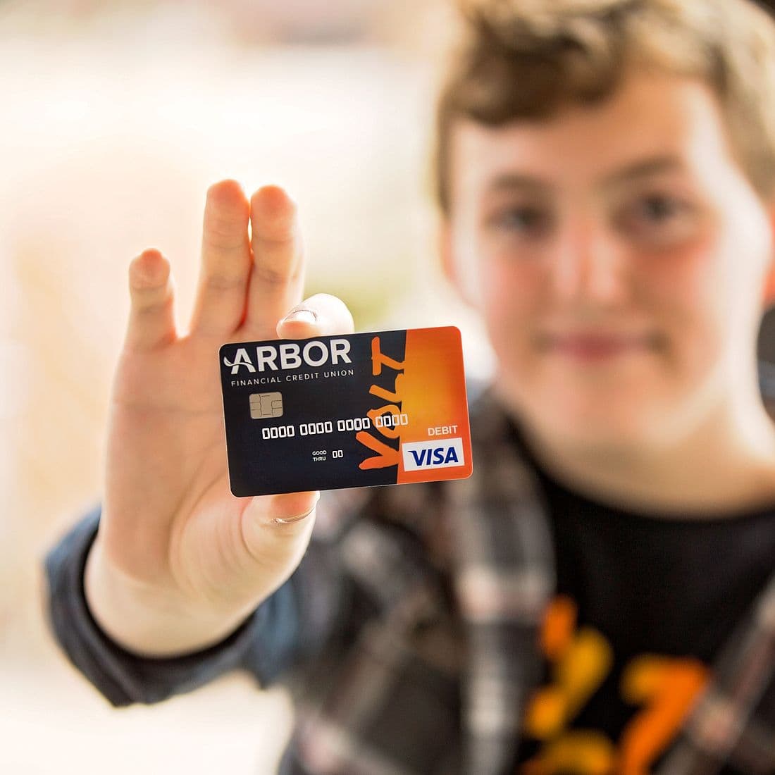 Boy holding Arbor Volt Visa Card