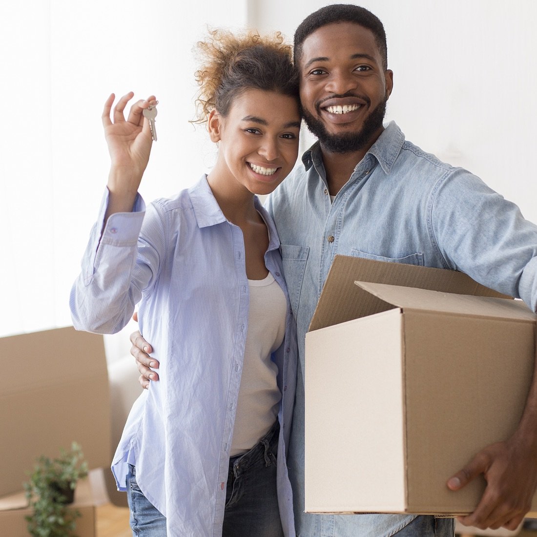 Couple with house key and moving box.