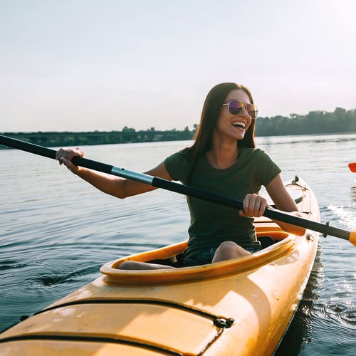 woman kayaking on Vacation paid for with account interest