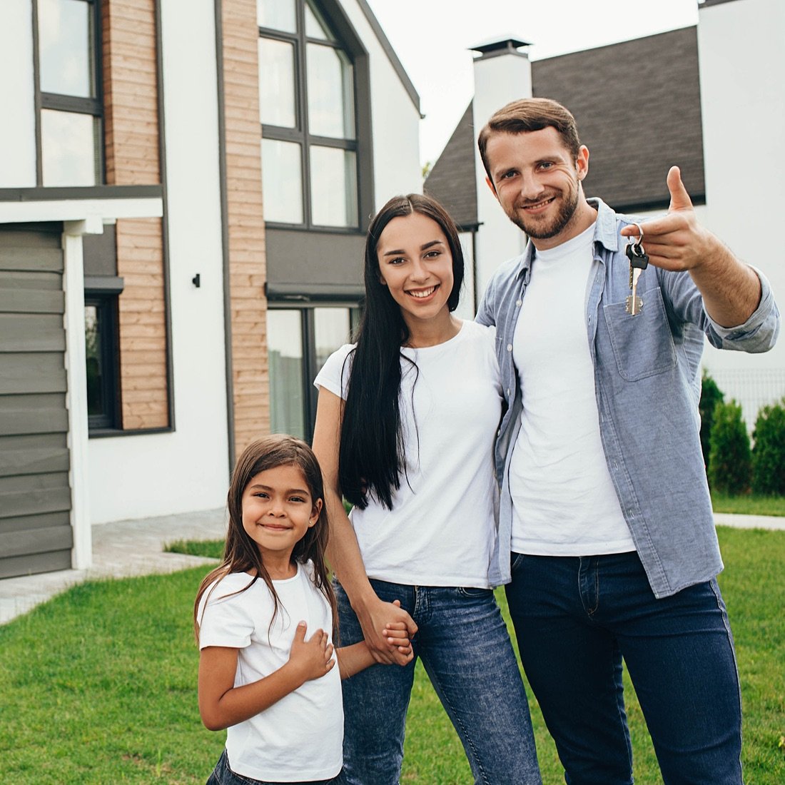 family with keys outside new home