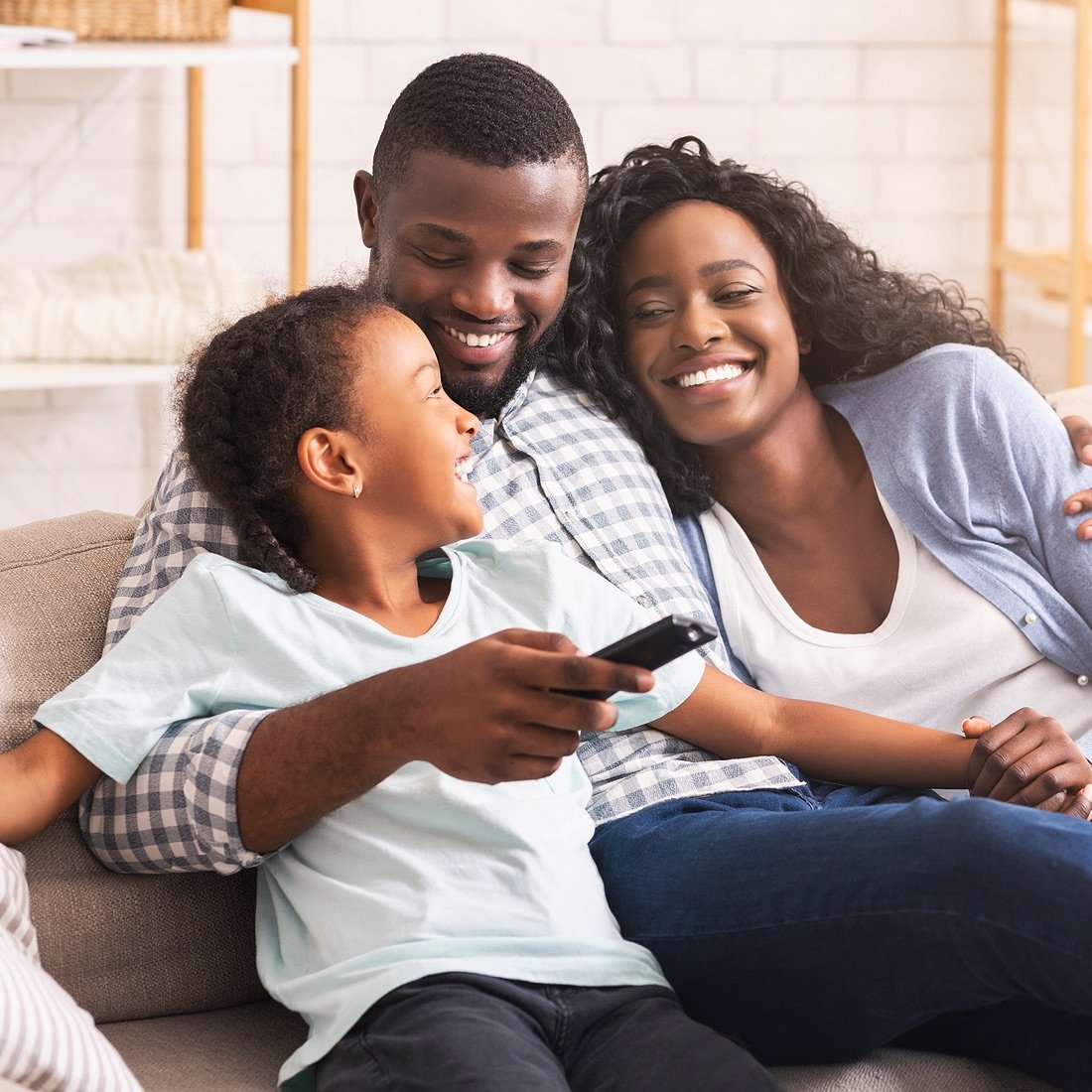 Family on the couch with tv remote.