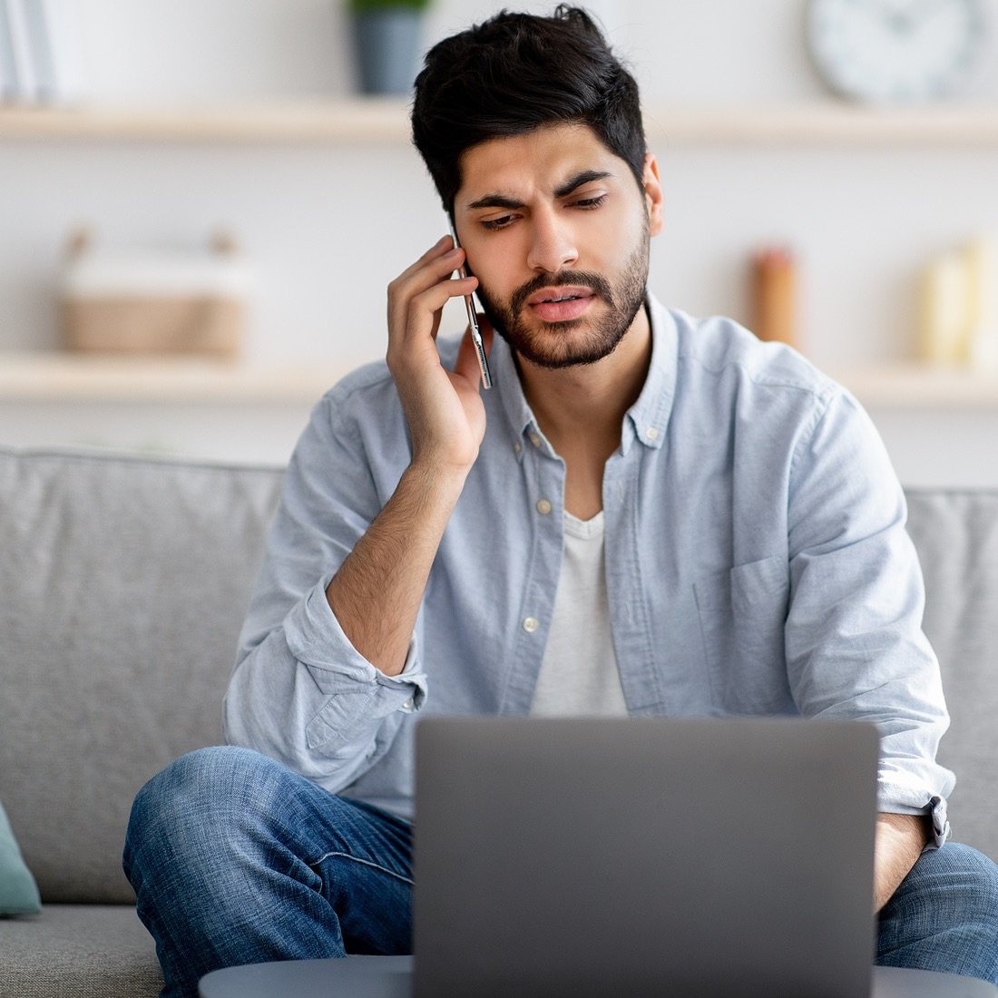 guy concerned on phone and laptop