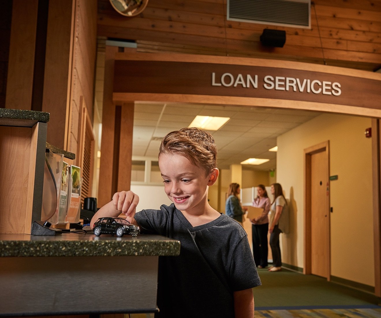 Child playing at a bank counter.