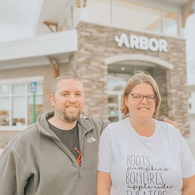 Michelle and Corey standing outside of an Arbor Financial Credit Union location.